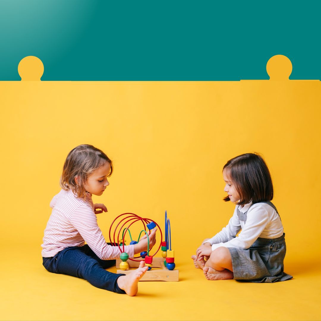 Two girls playing with a toy.